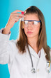 young woman looking at the chemical tube, focus on tube