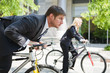Two business people racing on the bicycle showing competition