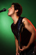 young man with guitar singing over green background