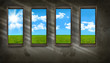 Dark room with windows overlooking blue sky and grass