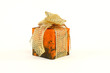 Small christmas present in orange paper with golden tie