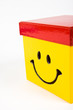 Smile on a yellow gift box with red cap.