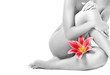 Female legs with pink lily isolated on white background Female legs with pink lily isolated on white background
