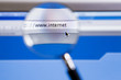 Photo: Magnifying glass on internet url of computer screen Magnifying glass on internet url of computer screen