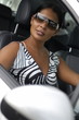 Femme branchée au volant d'une voiture.
