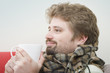 Handsome young man is getting warm drinking his coffee
