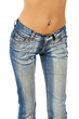 Young woman with pierced navel and faded denim jeans.