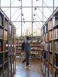 library shelves, young man walking by