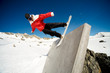 Snowboarder doing trick on wall ride, blue sky background