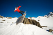 Snowboarder doing trick on wall ride, blue sky background
