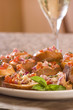 Plate of fresh bruschetta with a sprig of mint and a glass