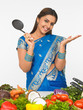 a smiling  woman with a cooking ladle, ready to cook