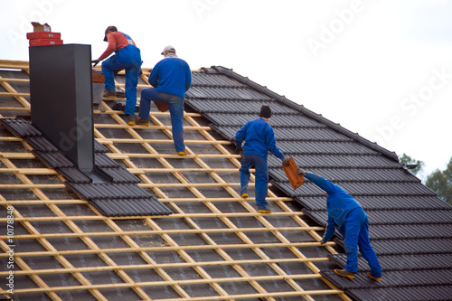 Foto: Dachdecker decken das Dach eines Hauses Dachdecker decken das Dach eines Hauses