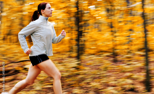 Photo: Beautiful young woman running in a fall forest. Beautiful young woman running in a fall forest.