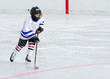 Photo: A young hockey player races with the puck. A young hockey player races with the puck.