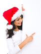 Beautiful christmas woman in santa hat holding empty board