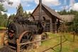 Old steam machine staying in a backyard, in the back old cottage