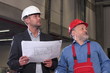 men in hardhats with blueprints