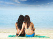two girls sitting on the beach