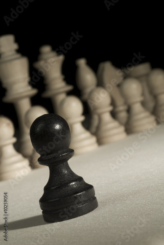 Photo: Black pawn against white pieces. Black pawn against white pieces.