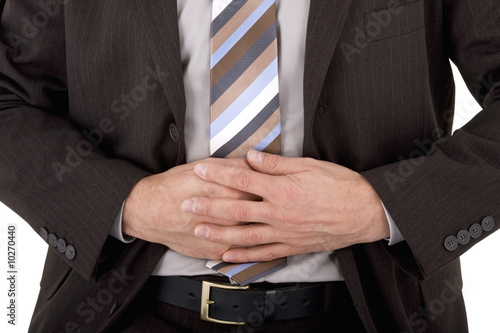 Photo: Businessman in pain holding his stomach isolated on white Businessman in pain holding his stomach isolated on white