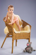 Baby girl stands on wicker armchair Baby girl stands on wicker armchair