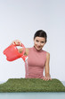 Beautiful girl watering artificial grass