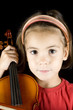 little girl with violin isolated on black background