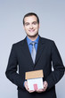 Young man holding a model of a house