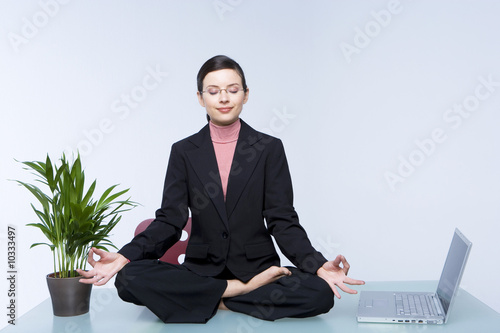 Foto: Young business woman doing yoga Young business woman doing yoga