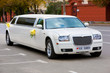 White wedding limousine on the road. Ornated with flowers. White wedding limousine on the road. Ornated with flowers.