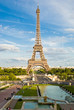 Eiffel Tower, with cloudy blue sky and sunny trees around. Eiffel Tower, with cloudy blue sky and sunny trees around.
