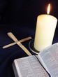 Lit cadle with bible open at Palm Sunday story, and palm crosses Lit cadle with bible open at Palm Sunday story, and palm crosses