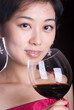 asian female holding goblet with red wine