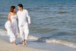 happy wedding couple walking along seashore