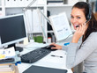 Closeup of a woman working on computer and wearing headset