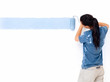 Female painter painting a wall with a roller