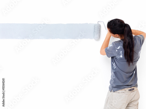 Female painter painting a wall with a roller