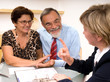 Photo: Mature couple talking to financial planner at home Mature couple talking to financial planner at home