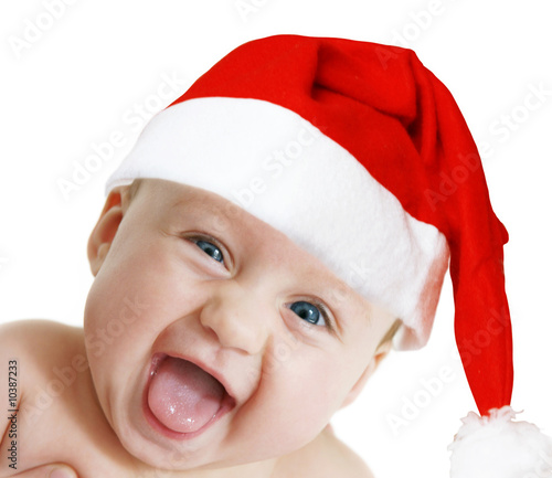 baby in Christmas bonnet looks at camera, on white