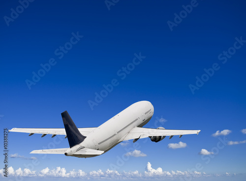 Civil airliner over a deep blue sky with some cloud