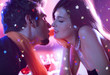 Young happy kissing amorous couple at celebration
