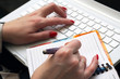 Woman works on a white laptop.