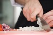 Chef cutting the onions on a wooden board