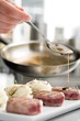 Chef add sause to a beef on professional kitchen