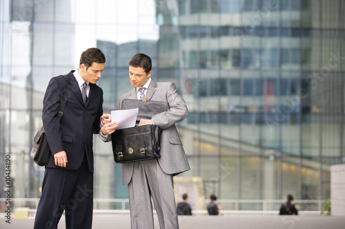 hommes d'affaires négotiant un contrat devant immeuble hommes d'affaires négotiant un contrat devant immeuble