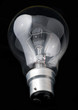 An incandescent tungsten light bulb on a black background