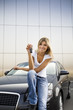 Young woman holding keys to new car.
