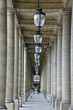 Man and woman walking away from camera between row of columns