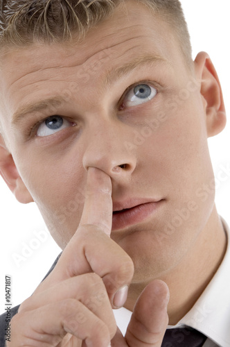 Photo: man picking his nose and looking upward on an background man picking his nose and looking upward on an background